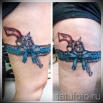 Fotó a harisnyakötő tetoválásról, pisztollyal és kék masnival