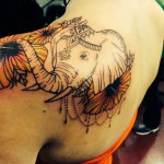 Индийски татуировка на слон и цветя на лявото рамо на момичето