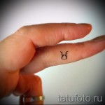 Fotó a Bika csillagjegy kész tetoválásáról - mikro tetoválás az ujján egy lány számára