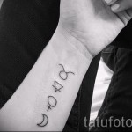 Fotó a Bika csillagjegy kész tetoválásáról - több szimbólum a karon lévő oszlopban