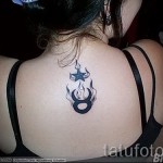 Fénykép a kész tetoválásról a Bika állatövi jelről - tűz szimbólum és csillag a nő hátán