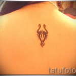 Fotó a Bika csillagjegy kész tetoválásáról - a lány lapockája közötti szimbólum