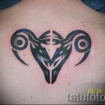 Fotó a Bika állatöv kész tetoválásáról - törzsi, vonalakkal a lapockák között - a férfi hátán