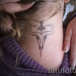 Fotó a Bika állatövi jel kész tetoválásáról - koponya és kard a lány nyakán