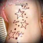 csillag tetoválás a lány oldalán és betűk szavakkal