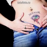 Tetováló szemek a gyomorban - egy kész tetováló munka a lány testén