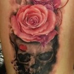 koponya és vörös rózsa tetoválás a lány lábán