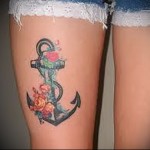 színes tetoválás horgonnyal a lábán