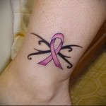 rózsaszín szalagos tetoválás a lány lábának alján