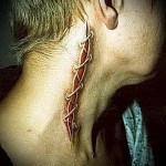 durva varrás a testen - tetoválás az ember nyakán - fotó