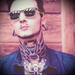 homokóra és szárnyak Ádám almáján - tetoválás az ember nyakán - fotó