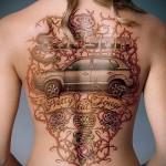 automobil i ruže s tetovažom trnja na leđima žene