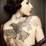 crna vrana u letu i tetovaža ruža na leđima