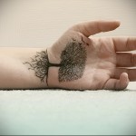 Csupasz fa tetoválás hosszú gyökerekkel a csuklóján