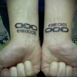 tetoválás lánccal és felirattal két kéz csuklóján