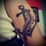 horgonytetoválás a karon, tollal