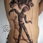 bábjátékos egy férfi oldalán tetoválásban