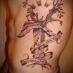 fa és a nap egy tetoválásban az ember oldalán