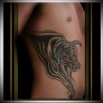 bika tetoválás egy férfi oldalán