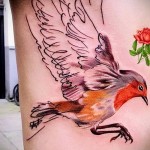 fényes madár tetováláson az ember oldalán