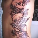 koponyák és rózsák tetováláson az ember oldalán