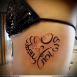 napis w kształcie serca - tatuaż z boku kobiety