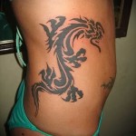 Plemienny smok - tatuaż z boku kobiety