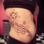 gwiazdy i imię w lokach - tatuaż z boku kobiety