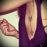 strzałka w dół - tatuaż z boku kobiety