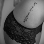 jednowierszowy napis po łacinie - kobiecy tatuaż z boku