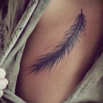 niezwykłe odwrócone pióro ptaka - tatuaż z boku kobiety