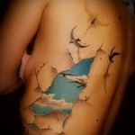 mewy i niebo - tatuaż z boku kobiety