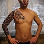 tetoválás egy fiatal férfi arcán és karján