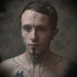 fiatal srác, tetoválással az arcán