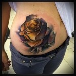 Татуировка на розова пъпка на момичешки корем