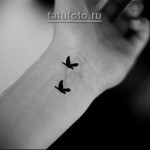 czarny tatuaż 2 ptaki na nadgarstku - kobieta