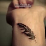 pióro - tatuaż na ramieniu kobiety