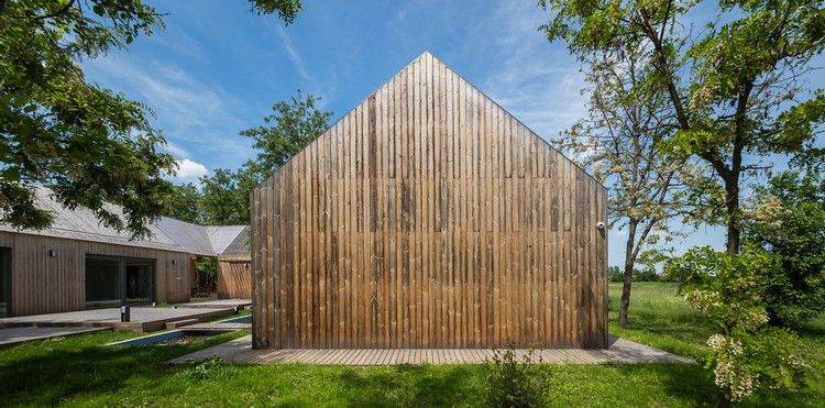 moderný statok trojstranná budova nádvoria vertikálna drevená fasáda