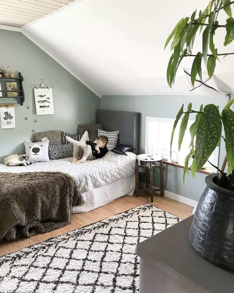 Škandinávska detská izba s posteľou pod šikmým stropom a zelenými stenami