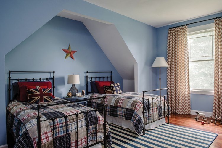 Malý šikmý strop natretý na modro s dvoma kovovými posteľami