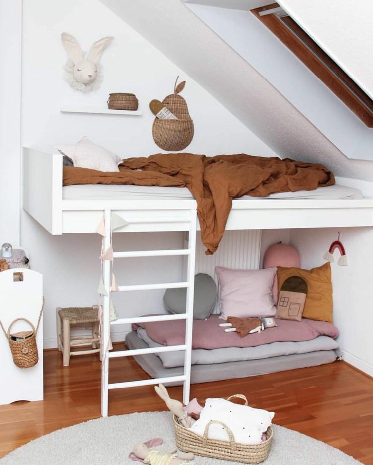 Veľká podkrovná posteľ pod šikmou strechou s rebríkom a priestorom na sedenie pod ňou