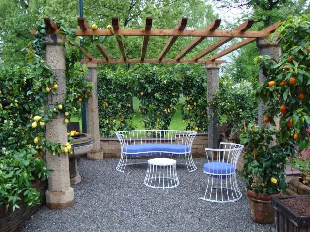 malá terasa dizajnová pergola kamenné stĺpy štrk kovový nábytok citróny