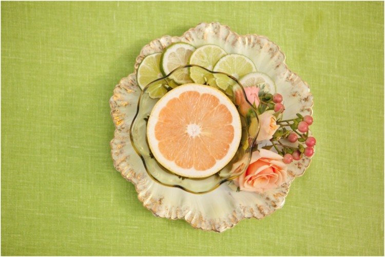 Grapefruit na dezert, ozdobený limetkami a ružami dekorácia stola-nápady-dezert-tanier-sklenená misa-grapefruit-limetka-ruža-bobule ľubovníka bodkovaného-koral-zelená-obrus