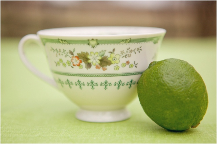 Šálka čaju a limetka na zelenom obruse dekorácia stola-nápady-šálka-motív-limetka-zelená-biela-obrus