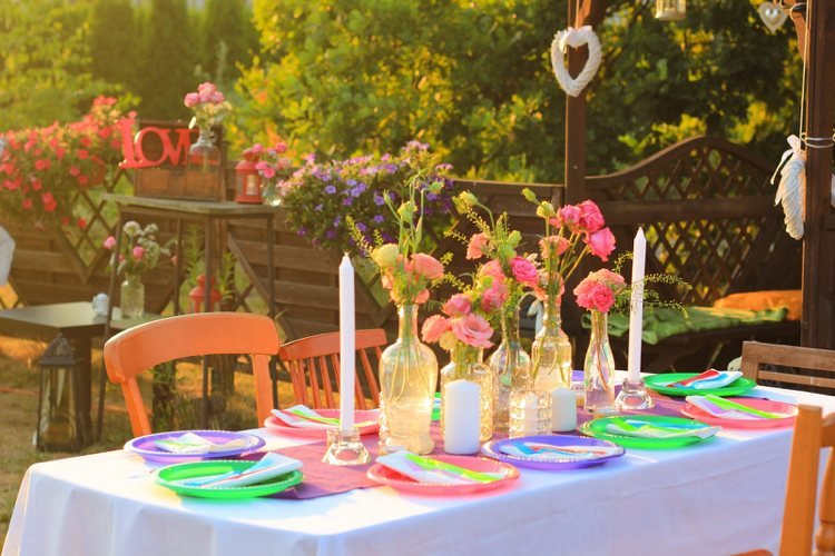 Zoskupte veľké a malé sklenené vázy dekorácia stola-neskoré leto-sklenené-fľaše-rezané kvety-oranžové-stoličky