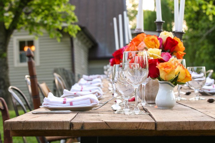 Kvetinové úpravy s červenými a oranžovými ružami dekorácia stolu-neskoré leto-drevo-jedálenský-stôl-ruže-kytice-oranžovo-červené