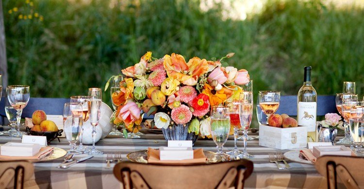 Kytica s oranžovými kvetmi a marhuľami Dekorácia stola v kombinácii kytice a marhúľ na konci leta