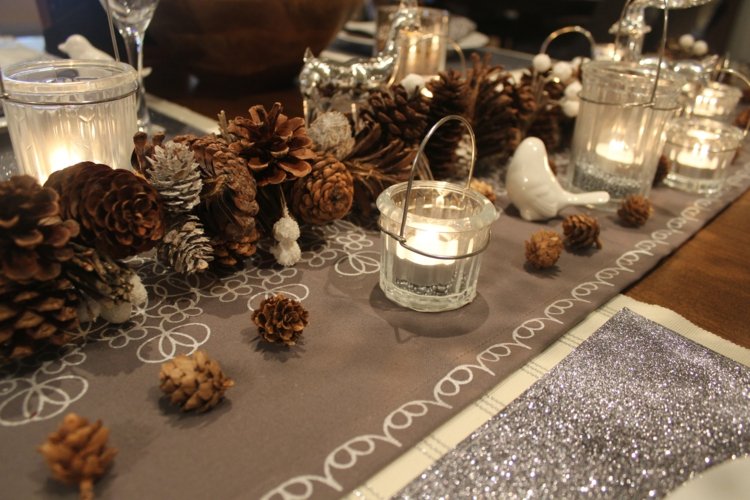 Romantická dekorácia na stôl z borovicových šišiek so sivým behúňom na stôl a množstvom sviečok sviečky dekorácia stola v zime šišky nápad bežec na stôl svadba