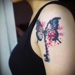 Trash Polka Tattoo - motyl i klucz na dłoni dziewczyny