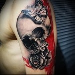 Trash Polka Tattoo - czaszka, motyl i róża na ramieniu